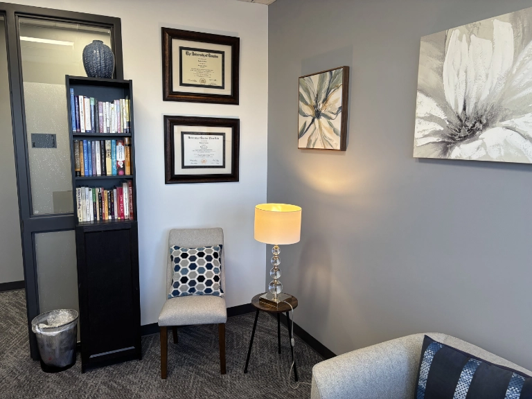 Therapy office corner with professional library and Ramiro Castano's credentials on display